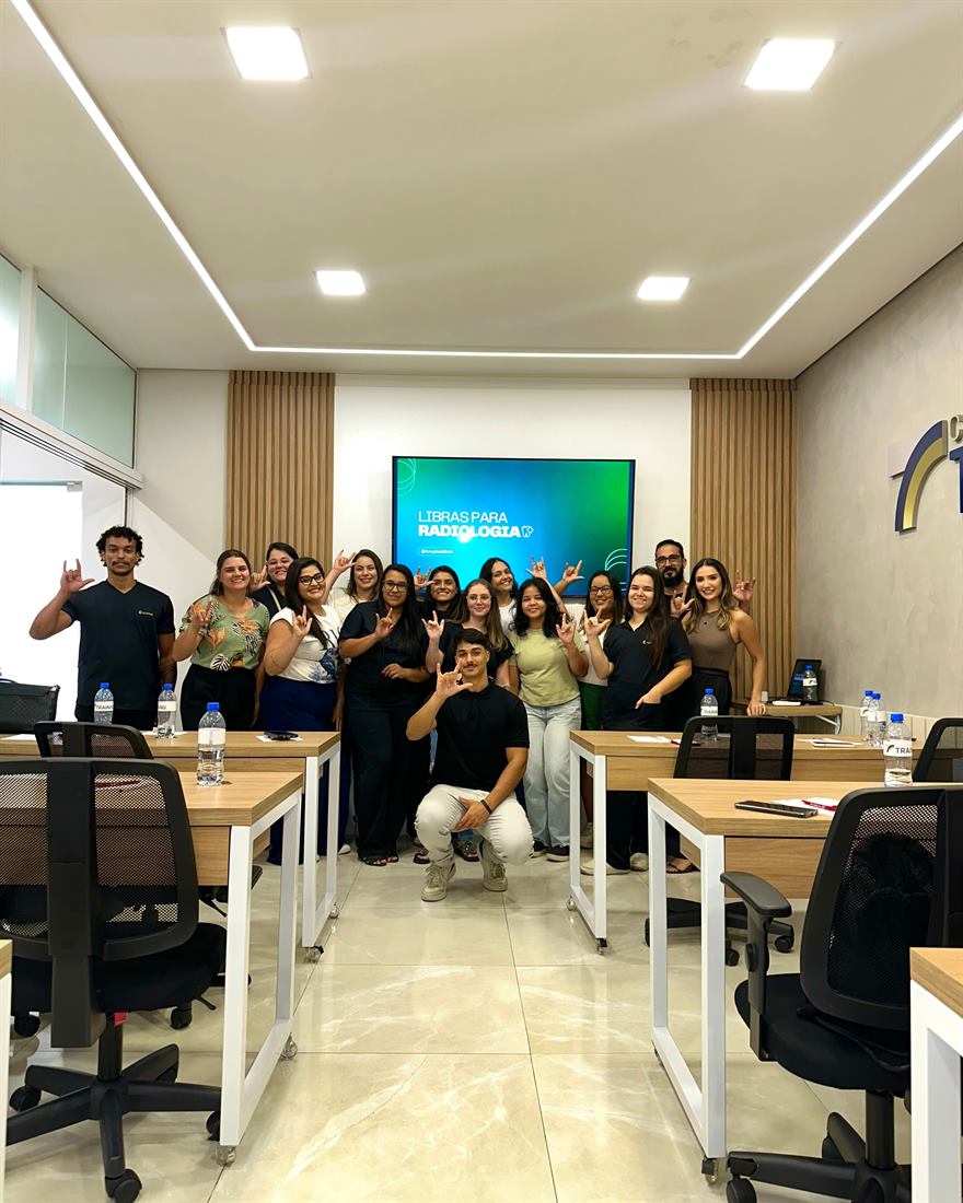 Turma de profissionais de radiologia fazendo o sinal de amor em Libras ao fim do treinamento com Tony Alves