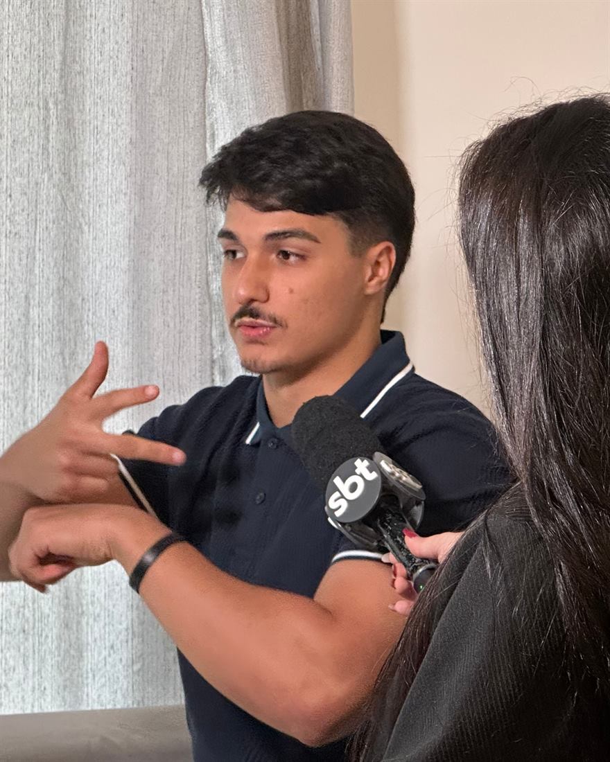 Tony Alves sinalizando em Libras durante entrevista ao SBT